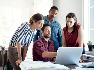 Four colleagues looking a PC screen